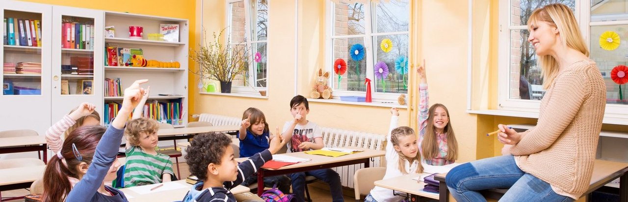 Im Unterricht Klassenzimmer mit Kindern und einer Lehrerin